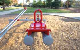 red and gray seesaw in the playground